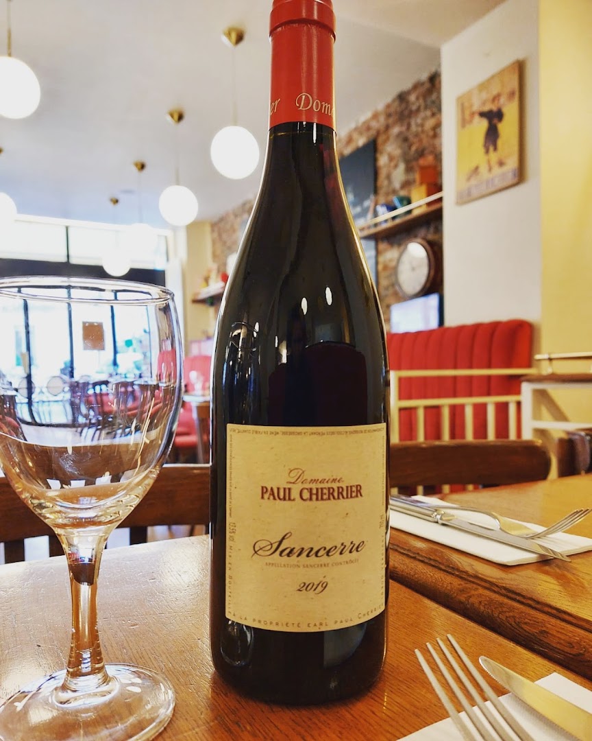 Une bouteille de Sancerre et des verres devant la salle vide